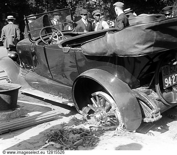 CAR ACCIDENT,  c1919. Men examining a wrecked car on the side of a street. Photograph,  c1919.