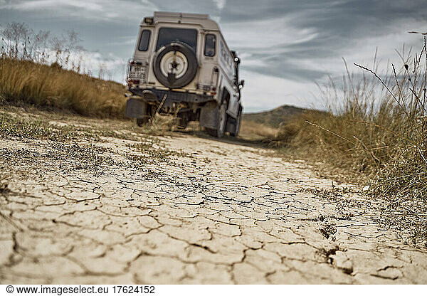 Car driving on barren landscape