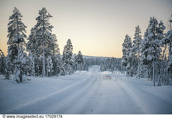 Car driving on icy snow covered roads on a road trip while travelling in Lapland inside the Arctic Circle in Finland