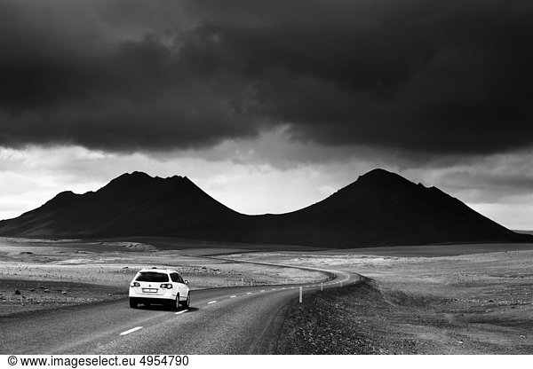 Car in landscape with silhouette of mountain
