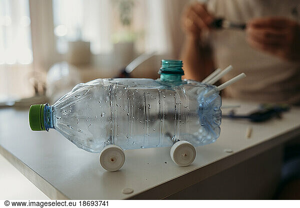 Car made from plastic bottle on table at home