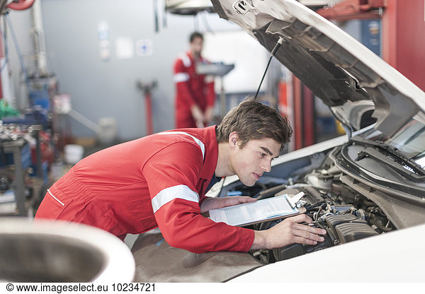 Car mechanic at work in repair garage