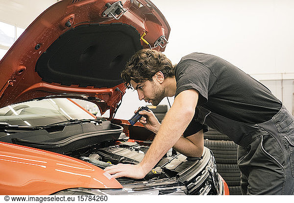 Car mechanic in a workshop working at car