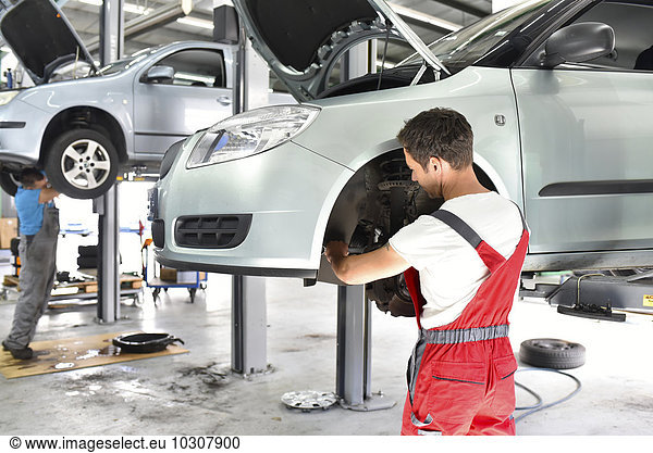 Car mechanic working in repair garage  repairing brake