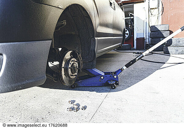 Car with tires removed at auto repair workshop