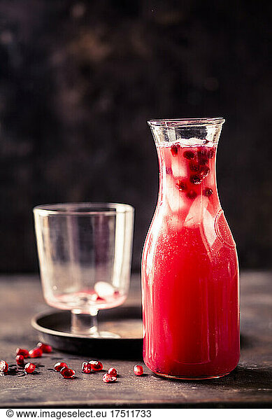 Carafe of pomegranate fizz with pomegranate juice,  ice cubes and tonic water
