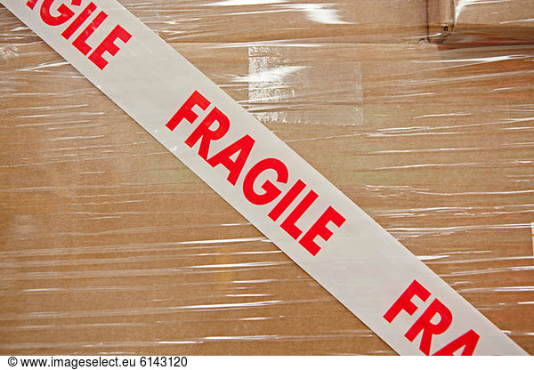 Cardboard box with parcel tape saying fragile