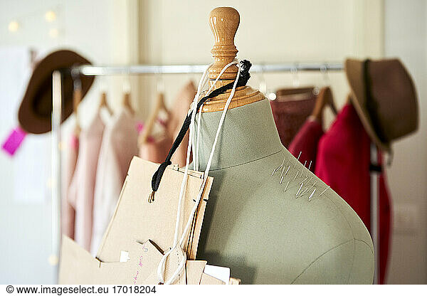 Cardboards hanging on dressmaker's model with straight pins at design studio