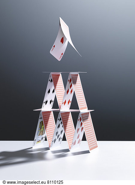Cards jumping above house of cards