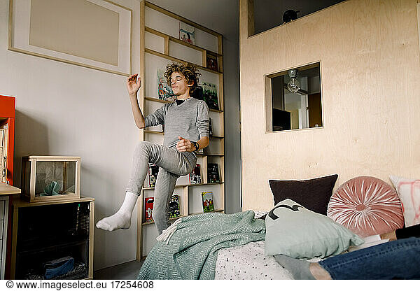 Carefree boy dancing in bedroom at home