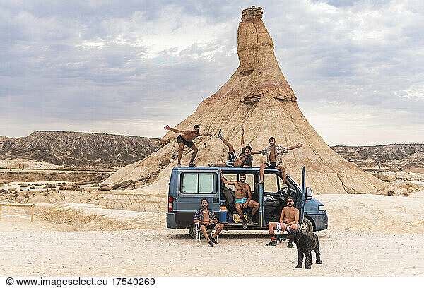 Carefree friends with dog and van at Bardenas Reales  Navarra  Spain