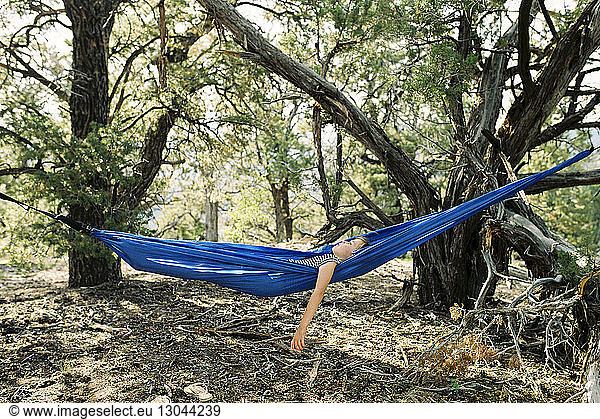 Carefree girl resting in hammock at forest