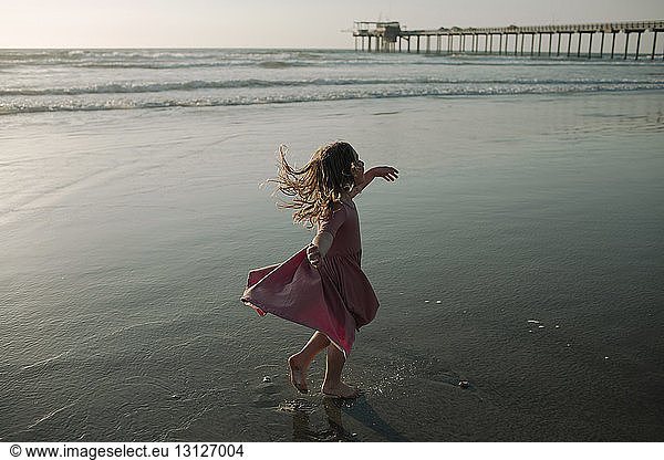 Carefree girl spinning at beach