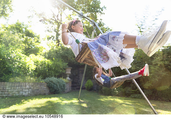 Carefree girls swinging in backyard