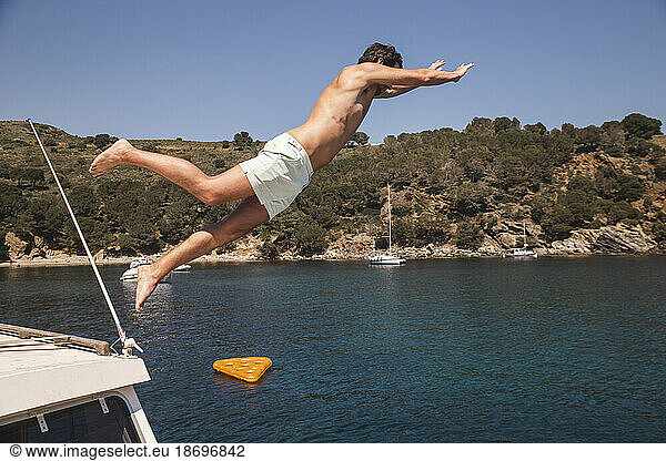 Carefree man jumping from yacht in sea