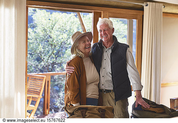 Carefree senior couple laughing in hotel room