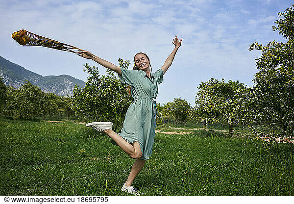 Carefree woman enjoying on grass in orange orchard