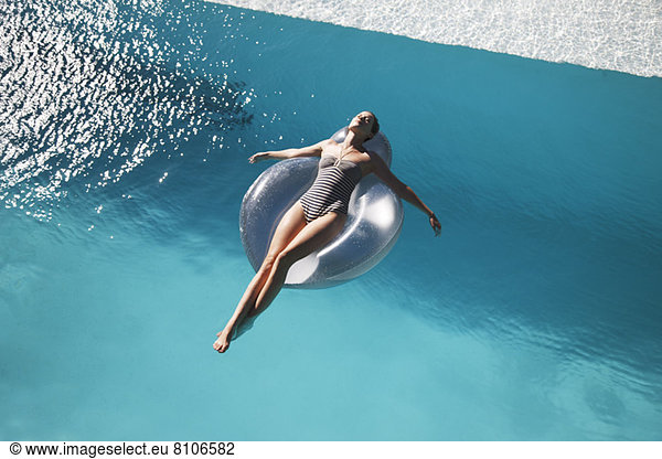 Carefree woman on ring in swimming pool