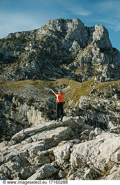 Carefree woman with arms outstretched standing on mountain at Cares Trail in Picos De Europe National Park  Asturias  Spain