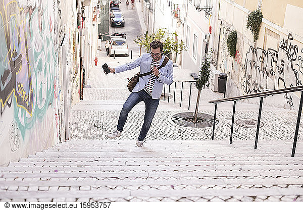 Carefree young man on stairs in the city  Lisbon  Portugal