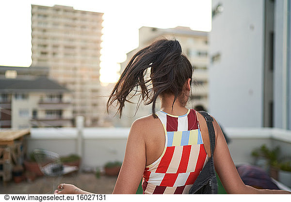 Carefree young woman dancing on urban rooftop