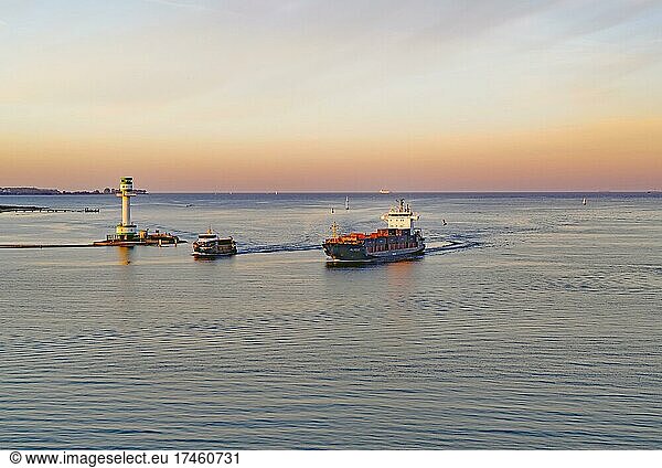 Cargo ship and passenger ferry in the Kiel Fjord at sunset  lighthouse  Kiel  Schleswig-Holstein  Germany  Europe