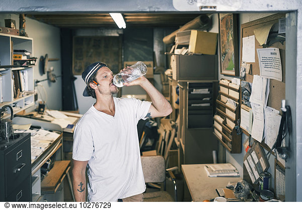 Carpenter drinking water in workshop