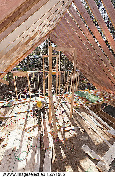 Carpenter working under rafters