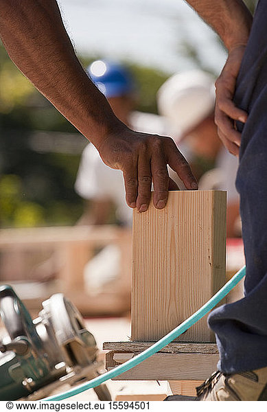 Carpenters positioning wood trim at a construction site