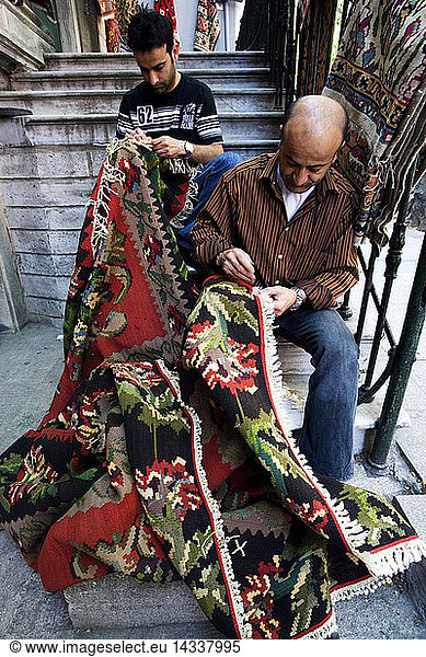 Carpets repairer doing the job outside his own shop  Istanbul  Turkey  Europe