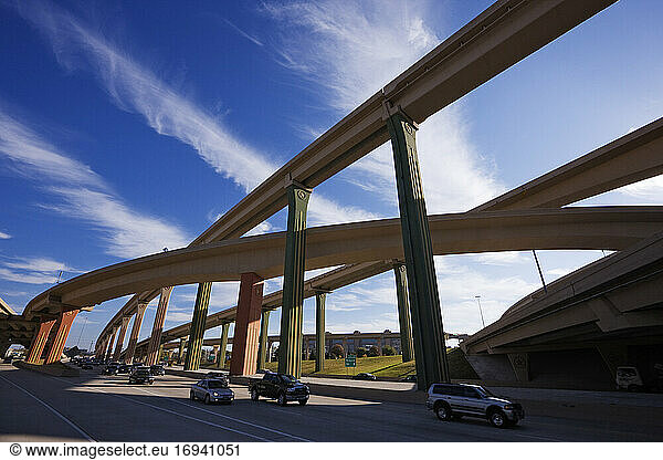 Cars on a highway with elevated roads above.