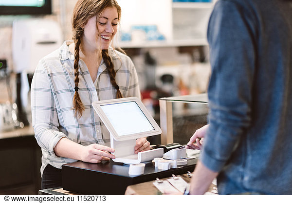 Cashier attending to customer in cafe