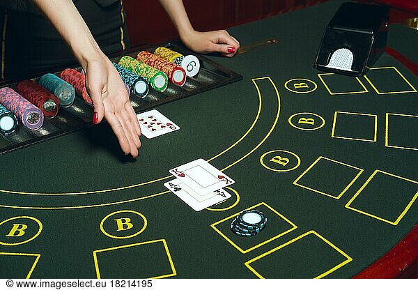 Casino poker table with chips and cards. Winning combination. Hand of Croupier open cards