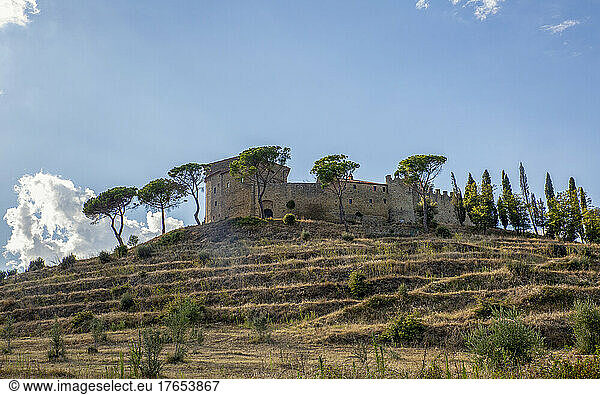 Castello di Montegualandro and trees under blue sky  Castiglione del Lago  Umbria  Italy