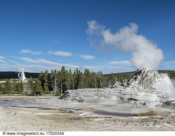 Castle Geyser steaming  with Old Faithful erupting behind  in Yellowstone National Park  UNESCO World Heritage Site  Wyoming  United States of America  North America