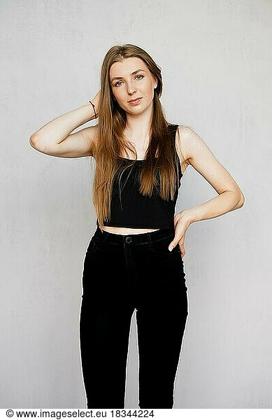Casual Porträt von niedlichen Mädchen in ärmellosen T-Shirt und engen schwarzen Jeans