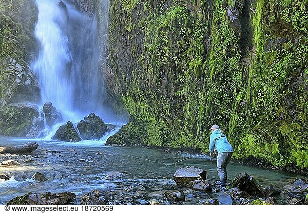 Cathy Beck casts into a beautiful waterfall while fly fishing in Chile
