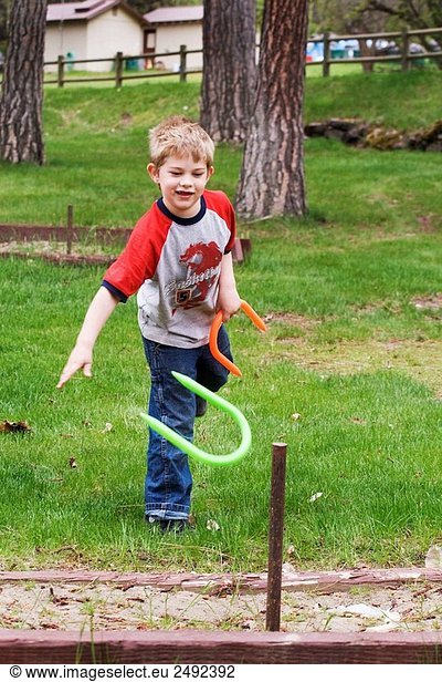 Caucasian boy  5-10  playing with plastic horseshoes