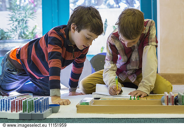 Caucasian boys working together in classroom