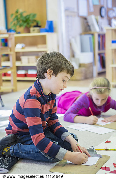Caucasian children writing in classroom