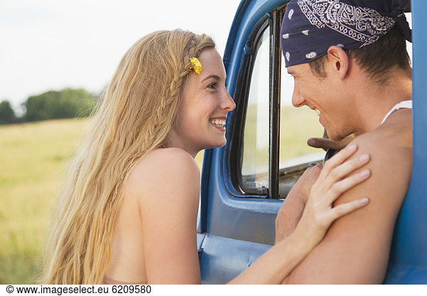 Caucasian couple talking near old-fashioned truck
