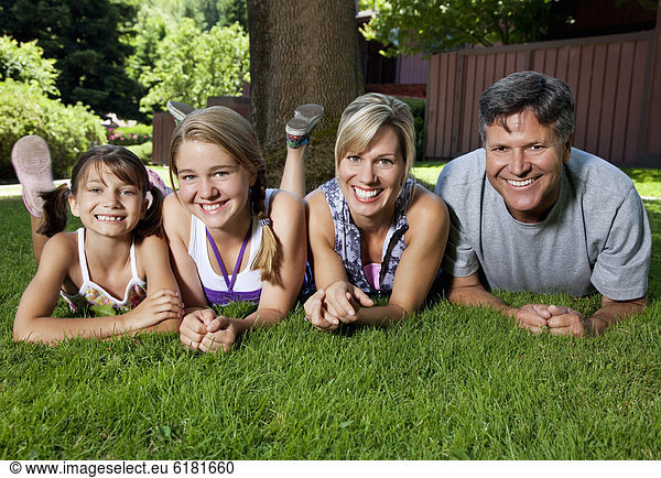 Caucasian family laying in grass