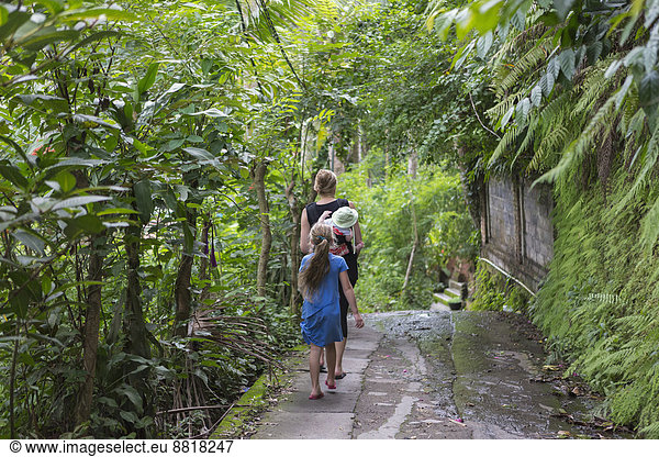 Caucasian family walking in tropical garden