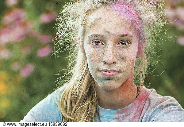 Caucasian girl covered in colored powder after color run