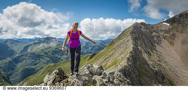 Caucasian girl hiking on rocky mountain