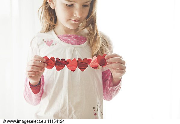 Caucasian girl holding heart-shaped bunting
