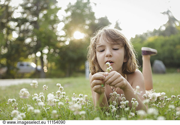 Caucasian girl playing with flowers in backyard