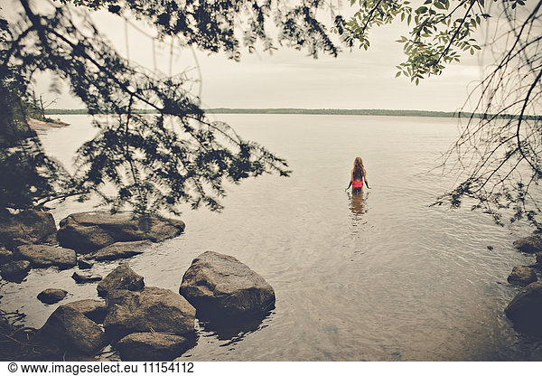 Caucasian girl standing in remote lake
