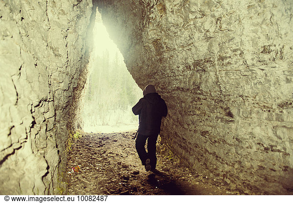 Caucasian hiker walking in rocky cave