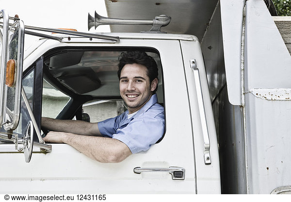 Caucasian man truck driver in company truck window.